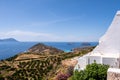 Sea view from Plaka Town on Milos Island, Greece, with whitewashed traditional houses and green vineyards