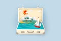 Sea view with a sailboat and tropical island with palm trees inside a suitcase Royalty Free Stock Photo