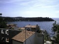 The sea is visible behind the roofs of houses of different storeys in the seaside town Royalty Free Stock Photo