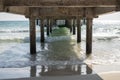 Sea water and beach view under long pier. Marine travel facility romantic view. Sunny day on tropical beach.