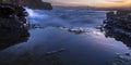 Sea water crashing on rocks in San Diego at sunset Royalty Free Stock Photo
