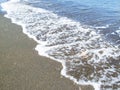 Sea water with foam on sand beach. Sea water tide on beach of tropical island.