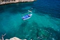 Sea water and granite stones. Boats above coral reef. Spain.