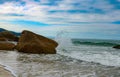 Sea water hitting the stone. Sea splashing on the rock on the beach. Beautiful day. Royalty Free Stock Photo