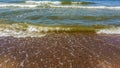 Sea water with little waves and many stones shore