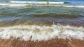 Sea water with little waves and many stones shore