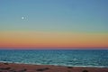 sunset at the beach and moon rise at the horizon in summer day