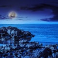 Sea wave breaks about boulders at night Royalty Free Stock Photo