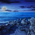 Sea wave breaks about boulders at night Royalty Free Stock Photo