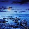 Sea wave breaks about boulders at night Royalty Free Stock Photo