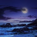 Sea wave breaks about boulders at night Royalty Free Stock Photo