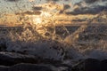 Sea wave breaks about stones, splashes at sunset