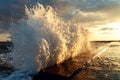 A large wave breaks about a breakwater close-up against a sunset background. Seascape Royalty Free Stock Photo