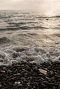 sea wave crashes on the pebbles on the shore