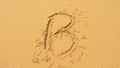 The sea wave erases the inscriptions written on the sand. top view, the letter b