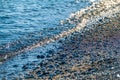 Sea wave with foam on a pebble beach Royalty Free Stock Photo