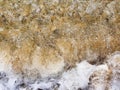 Sea wave mixes with sand, sea foam, water splash. Top view. Beach sunset abstract background Royalty Free Stock Photo