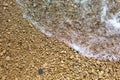 Sea wave on a pebble beach made of small stones. Sea holidays, travel background Royalty Free Stock Photo