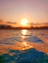 Sea wave splash, sunset, ocean water surf, sunrise, tropical island beach dawn, sun reflection, summer holidays, vacation Royalty Free Stock Photo