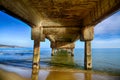 Sea waves and the beach under the old pier Royalty Free Stock Photo