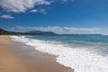 Beautiful sandy beach, waves, foam, sunny summer day, blue sky and white clouds. Royalty Free Stock Photo