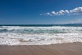 Sea waves on beautiful paradise sandy beach, lot of white foam, blue sky with few clouds. Royalty Free Stock Photo