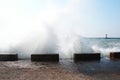 Sea waves breaking on the pier, resort embankment, sun glare on the water.