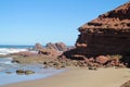 Sea waves coming to the red rocks on the shore