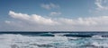 Sea waves crash on the rough rocky shore