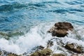 Sea waves crashing with splash by the stone rocks in windy day. Royalty Free Stock Photo
