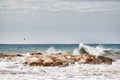 Sea waves crashing strongly against a breakwater near the shore of the beach Royalty Free Stock Photo