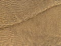 An unusual fine pattern background creates sand at a shallow depth under the sun\'s rays. In brown tones with a diagonal cut Royalty Free Stock Photo