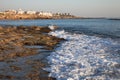 Sea waves with foam on the stony shore. Mediterranean town in th Royalty Free Stock Photo