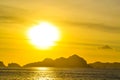 Sea, waves, hills illuminated sunlight through the clouds at sunset. El Nido Palawan Philippines