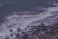 Sea waves hitting brown rocks