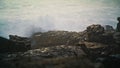 Sea waves hitting rocks making explosion closeup. Storm water foaming breaking