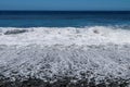 Sea waves hitting the stony coast. Waves turn into sea foam. Frothy sea water and bubbles. The Azores kill water. Background Royalty Free Stock Photo