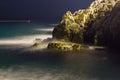 Sea waves lash line impact rock on the beach in night