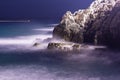 Sea waves lash line impact rock on the beach in night