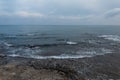 Sea with waves and rocks with sky and clouds. Seascape in the evening. Natural composition. Spain.