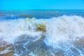 Sea waves roll on to shore with foam and sea spray.