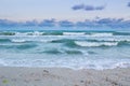 Sea waves rolling on empty beach, stormy cloudy sunrise