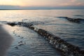 Sea waves on the sandy beach in sunset. Ladoga lake