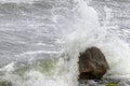 Sea waves during a storm break with splashes on a coastal stone