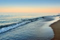 Sea waves wash the beach against backdrop of evening sky Royalty Free Stock Photo