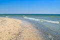 Sea waves wash the beach against a blue sky. Landscape on a wild beach. The sea in the summer Royalty Free Stock Photo