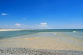 Sea waves wash the beach against a blue sky. Landscape on a wild beach. The sea in the summer Royalty Free Stock Photo