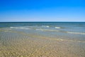 Sea waves wash the beach against a blue sky. Landscape on a wild beach. The sea in the summer Royalty Free Stock Photo