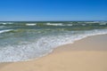 Sea waves wash the beach against a blue sky. Landscape on a wild beach. The sea in the summer Royalty Free Stock Photo