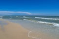 Sea waves wash the beach against a blue sky. Landscape on a wild beach. The sea in the summer Royalty Free Stock Photo
